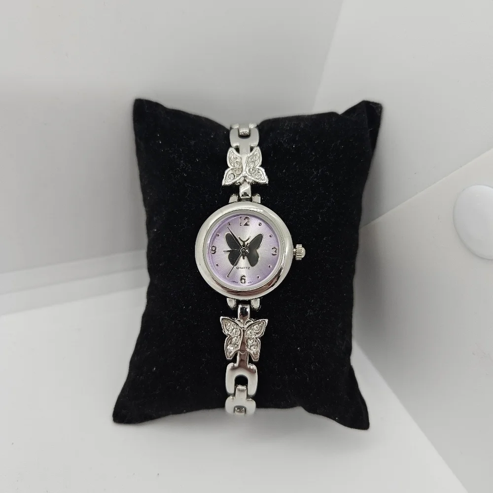 small silver tone watch with purple face and rhinestone butterflies